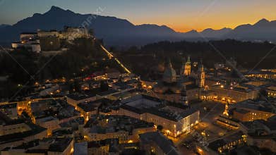 Salzburg at dusk with stunning mountain views and illuminated historic architecture, Austria. Aerial HDR evening shot of