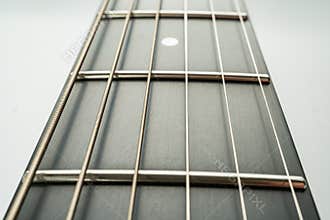 Close-up image of a polished guitar fretboard, showcasing metal frets and gradient color transition