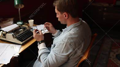 Soft-focused image of an author battling writer's block at his cluttered desk