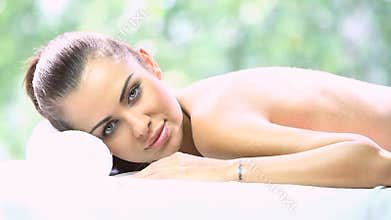 Beautiful woman is resting on spa bed