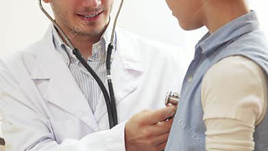 Doctor examines young girl’s lungs with a stethoscope and gives a thumbs up