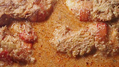 Delicious fish curry cooking with spices and cream in the kitchen