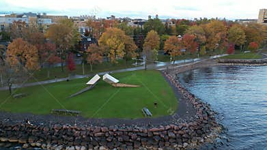 Drone view of Time sculpture with colorful trees on the Lake Ontario shoreline at Breakwater Park