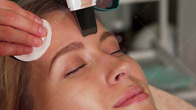 Young woman enjoying a rejuvenating ultrasonic facial treatment at a beauty salon