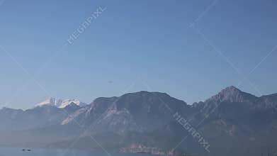 The F16 fighter performs aerobatics over the sea against the background of mountains