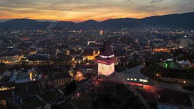 Aerial view of Uhrturm clock tower on Graz's Schloberg hill in the evening. Graz, Austria at dusk with the clock