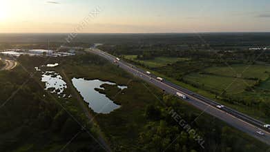 Aerial of the traffic on the highways passing through green fields at sunset in Kingston, Canada