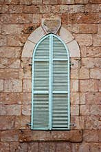 Jerusalem's ancient building's wall with blue aqua window shutters. retro filtered image