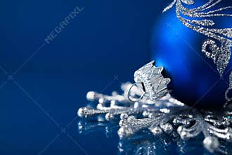 Blue and silver christmas ornaments on dark blue background