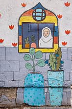 Cartoon-like mural of a woman in a window wearing a hijab