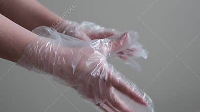 Female hands with disposable plastic gloves on gray background environmental hygiene and responsible food preparation