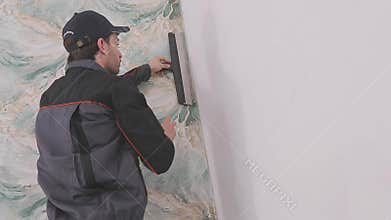 Trimming wallpaper in the corners of a room after wallpapering. Trimming excess paper.