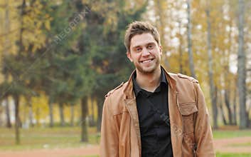 Portrait of attractive happy smiling stylish young man in autumn