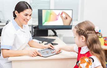 Hearing solution for child. Audiologist selecting a hearing aid for a little girl. Child needs good hearing aids so