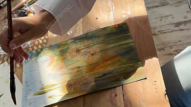 A Joyful Artist Proudly Showcasing Their Colorful Paint Brushes in a Bright and Inspiring Studio Environment