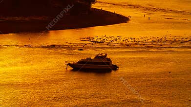 Luxury Boat on Shimmering Golden Sea at Dusk