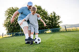Dad and son sharing passion for football and active lifestyle.