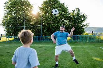 Dad and son sharing passion for football and active lifestyle.