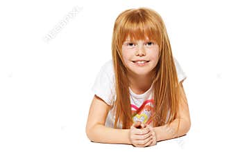 A cheerful little girl with red hair is lying ; isolated on the white