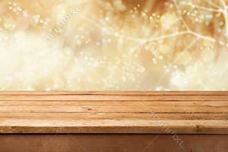 Golden bokeh background with empty wooden table for product montage display