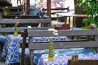 Outdoor Cafe Tables Decorated With Wildflowers In Summer
