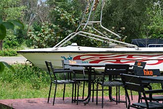 Motorboat Displayed Near Outdoor Riverside Cafe Seating