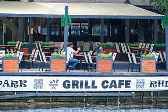 Riverside Grill Cafe Terrace With Visitors In Summer