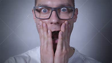 Portrait of amazed, scared man in studio. Close up.