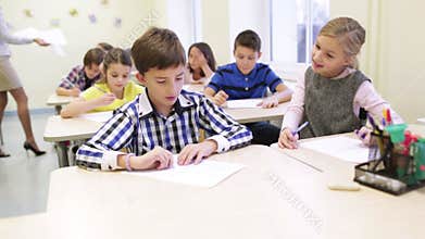 Group of school kids writing test in classroom