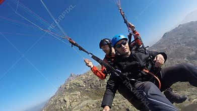 Paragliding over rocky hill