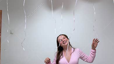 Joyful woman playing with balloons and laughing during a celebration
