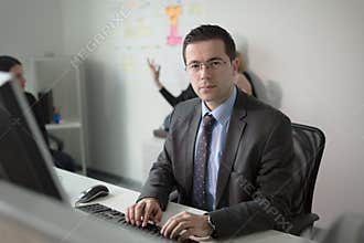 Serious devoted business man work in office on computer. Real economist business people, not models. Bank employees discussing