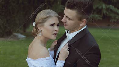 Beautiful wedding couple on green grass near the