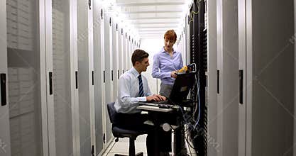 Technicians using digital cable analyzer on server