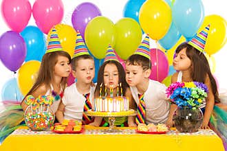 Kids celebrating birthday party and blowing