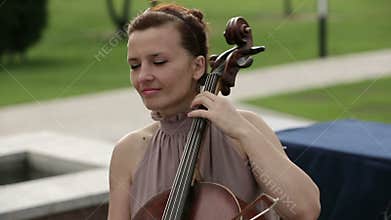 Musical quartet. Girl playing cello in a quartet of violinists. Close up.