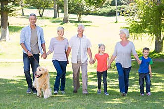Happy family walking in the park with their dog