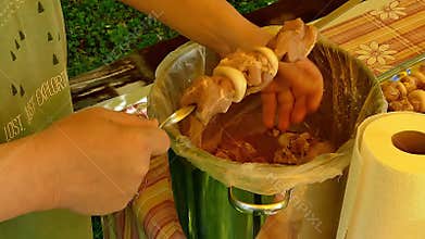 Marinated raw meat, chev-pofar with black gloves prepares, threading on a skewer, close-up.