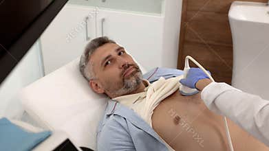 Heart ultrasound exam for male patient with ultrasound specialist while medical exam. Heart health exam with ultrasound