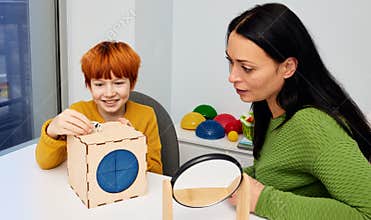 Speech therapy. Male child patient training his pronunciation with private child development specialist while session in