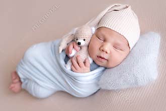 Newborn baby sleeps peacefully with teddy bear