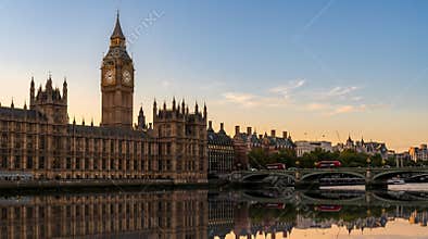 Iconic Big Ben clock tower and Houses of Parliament reflect majestically in the Thames River at sunrise