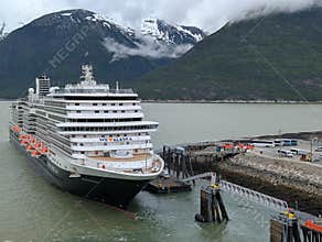 Skagway, Alaska 2026.06.16. Holland America Koningsdam docked in the port of Skagway with tall, snowy mountains in the background