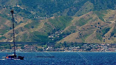 A swordfish fishing vessel passes through the Strait of Messina