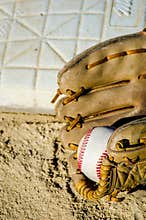 Baseball game mitt and ball on home plate / base