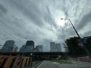 Rainy Amsterdam business district with modern office towers, tram wires