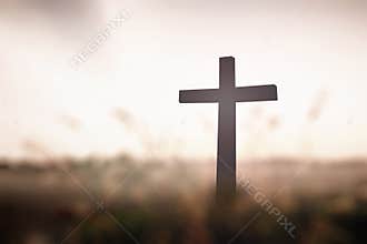 Christian Wood Cross in Nature Field at Sunset with Spiritual Easter Abstract Concept