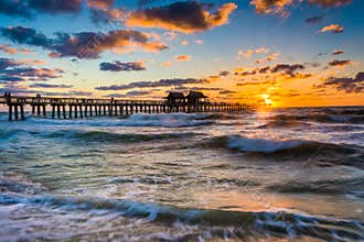 Sunset over the fishing pier and Gulf of Mexico in Naples, Florida.