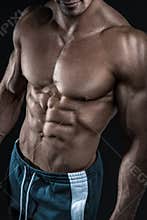 Strong athletic man fitness model showing torso muscles