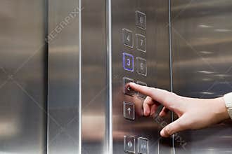 Female finger presses the button for the elevator